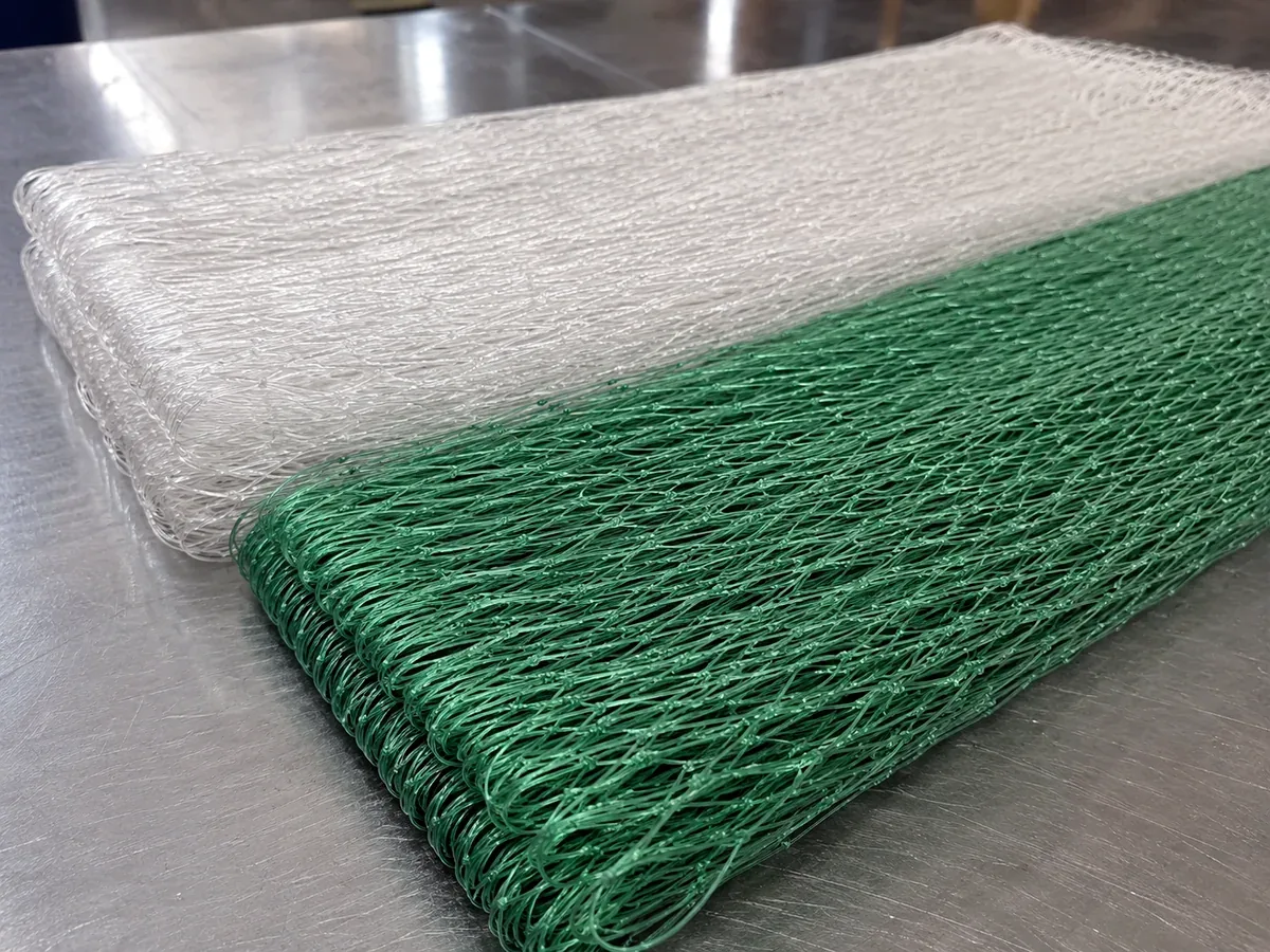 Green and transparent nylon gill net panels folded on factory table