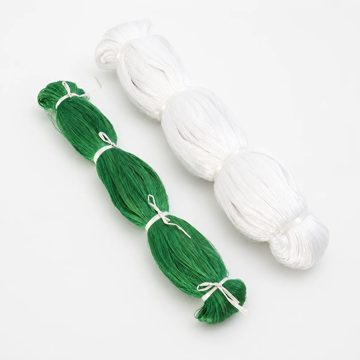 Green and white nylon netting bundles on a white background